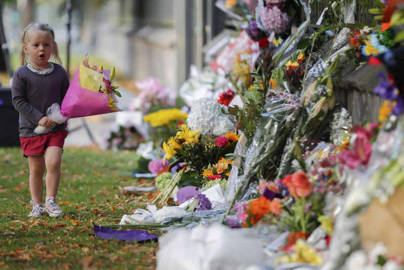 ニュージーランド(NZ)のモスクで起きた銃乱射事件の現場に花を供える女の子=NZ南部クライストチャーチで3月17日、AP