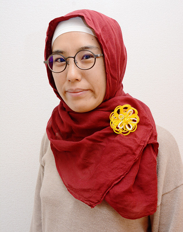 伊予水引のブローチを付けたヒジャブを巻く新山由佳理さん=松山市で、花澤葵撮影