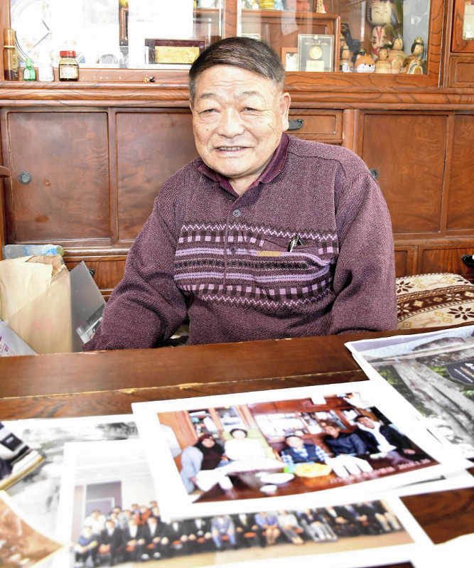 パラオや北原尾の写真を前に笑顔をみせる工藤静雄さん=宮城県旧宮村(現蔵王町)北原尾地区で1951年10月、増田昭世撮影