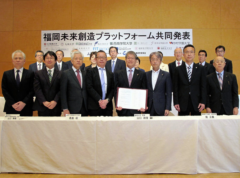 福岡未来創造プラットフォームに参加した18機関の関係者ら(中央の協定書を手にしているのが山口政俊・福大学長)