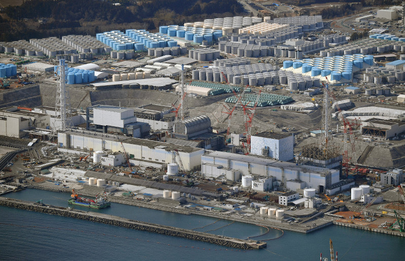 廃炉作業が進められている福島第1原発の1号機(右)から4号機。奥は処理水貯蔵タンク=福島県大熊町で2019年2月14日、本社ヘリから手塚耕一郎撮影