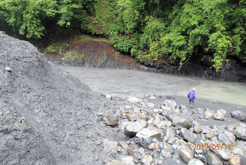 雨畑川沿いに放置された汚泥(左)=山梨県提供