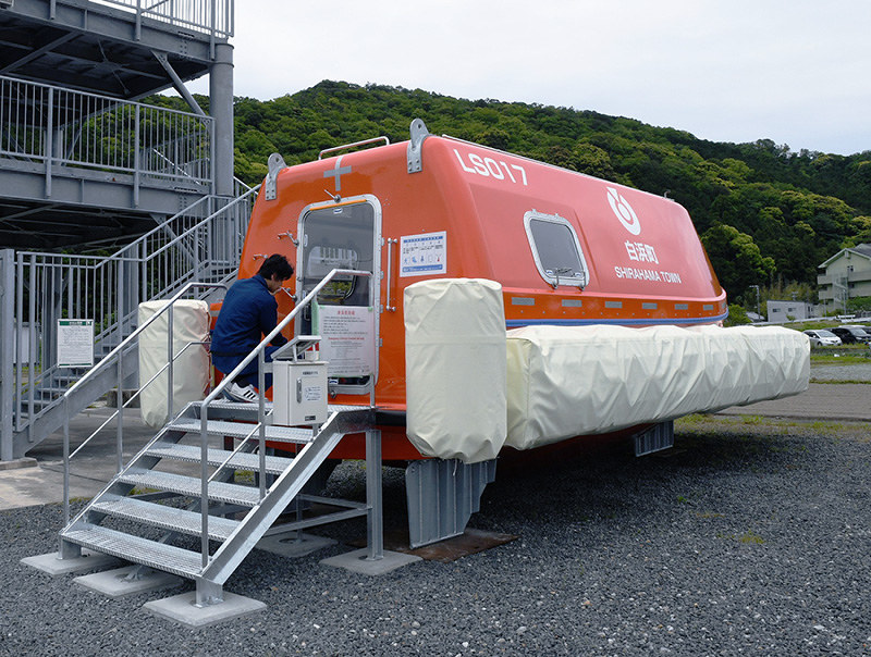 富田川口地区の津波避難タワー(左奥)のそばに設置された津波救命艇=和歌山県白浜町富田で、藤田宰司撮影