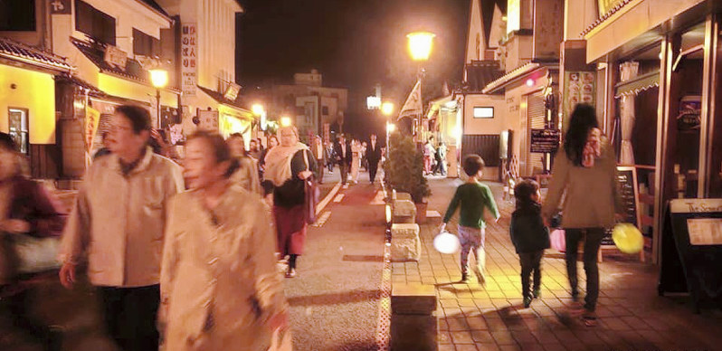 夜の成田山表参道をちょうちんを持って楽しむ参加者たち=昨年10月