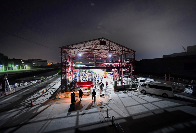 屋根と鉄骨だけが残った建造物では野外イベントや物販、飲食スペースとして使われている。両側はドック=大阪市住之江区で、久保玲撮影