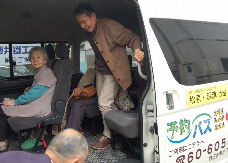 自宅前まで送ってくれた予約バスを降りる安生さん(右)。毎日のように利用しているという=栃木県鹿沼市で2019年5月14日、清水健二撮影