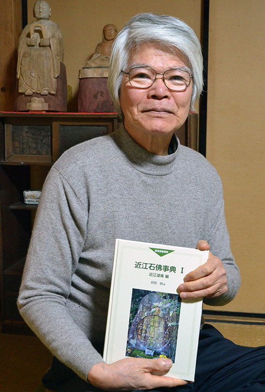 発刊した「近江石佛事典」を手にする卯田明さん=滋賀県草津市で、礒野健一撮影