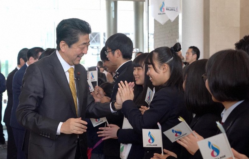 ハイタッチする安倍首相。古井氏は「やっぱり握手は大事」だという=2019年4月、POTETO提供