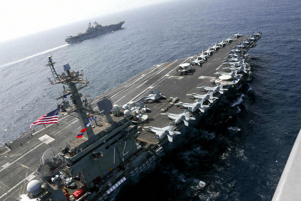 In this Friday, May 17, 2019, photo released by the U.S. Navy, the USS Abraham Lincoln sails in the Arabian Sea near the amphibious assault ship USS Kearsarge. Commercial airliners flying over the Persian Gulf risk being targeted by