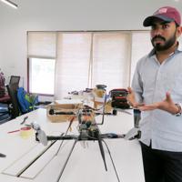 製作中のドローンについて説明するビクラム・シンさん=ニューデリー郊外で