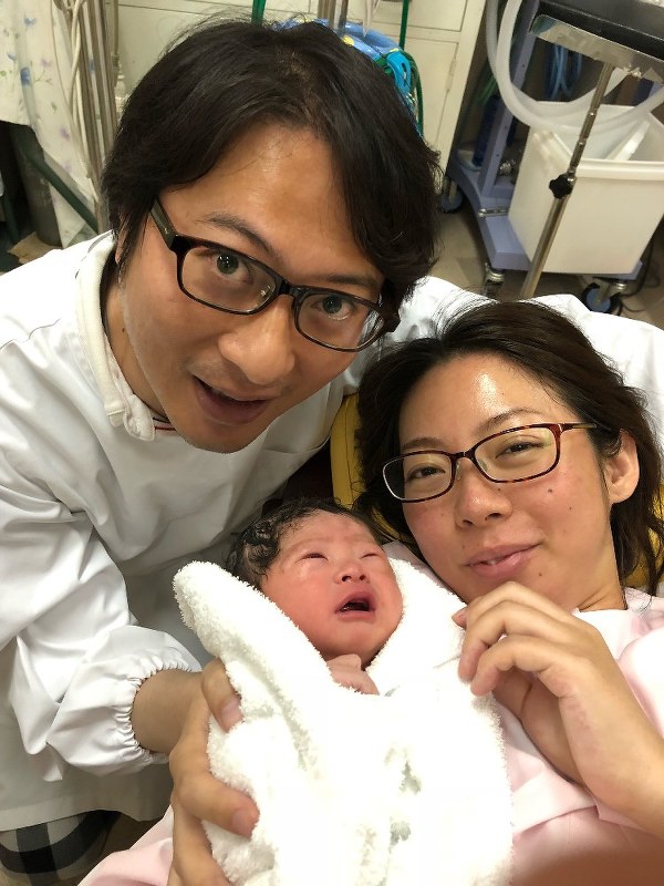 生まれたばかりの杏ちゃんを抱く松井さん夫妻=2018年7月、松井さん提供