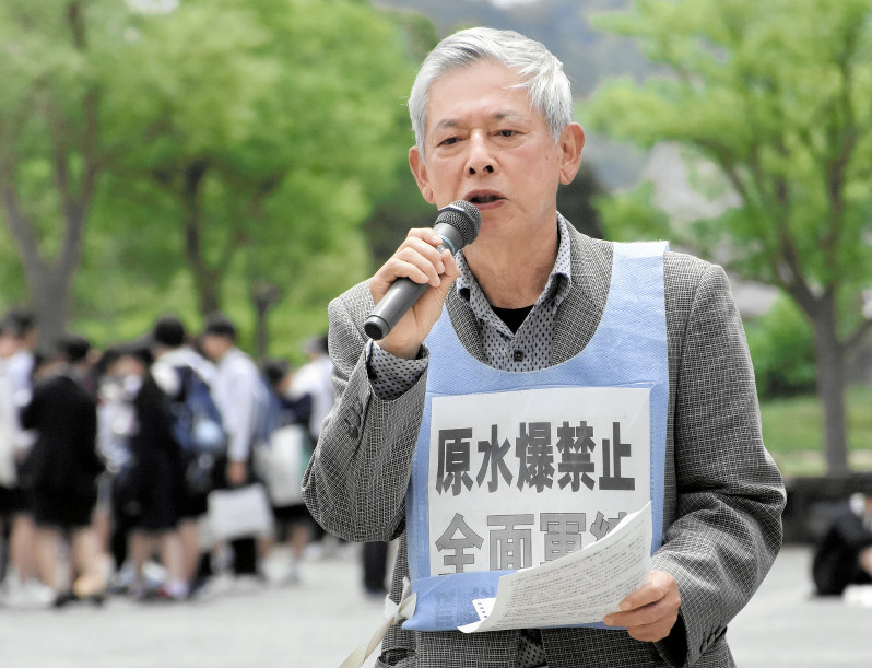 修学旅行生らが行き交う平和公園でマイクを握る川野浩一さん=長崎市松山町の平和公園で2019年5月9日、今野悠貴撮影