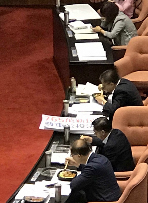 本会議場で討論・採決の最中に弁当を食べる台湾の立法委員(国会議員)たち。奥の女性議員はスマホで調べものをしている=台北市の立法院(国会)で2019年5月17日12時15分、福岡静哉撮影