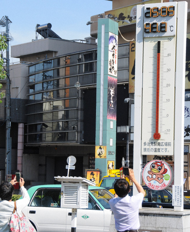 41.7度を示す「うながっぱ気温計」を写真撮影する市民ら=岐阜県多治見市のJR多治見駅前で2018年8月3日午後3時4分、立松勝撮影
