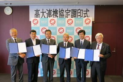 連携教育協定に関する協定書を手にする敬愛大の三幣利夫学長（左）や千葉敬愛短大の明石要一学長（右）ら