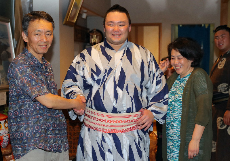 夏場所優勝を決め、母の石橋佳美さん(右)と父の靖さん(左)と握手して喜ぶ朝乃山=東京都墨田区で2019年5月25日午後7時1分、宮武祐希撮影