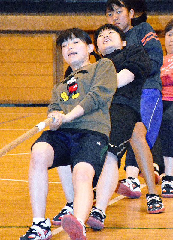 後輩たちを相手に綱を引く川染遼奈さん(手前)、けがをしないよう「ひかれ方」の練習も大切だという=松山市土橋町の雄郡小で、木島諒子撮影