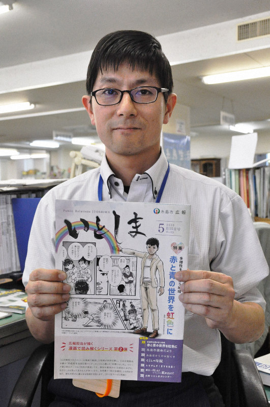 性の多様性を漫画で伝える広報誌を手にする田中伸治さん=福岡県糸島市役所で2019年5月22日午後4時27分、杣谷健太撮影