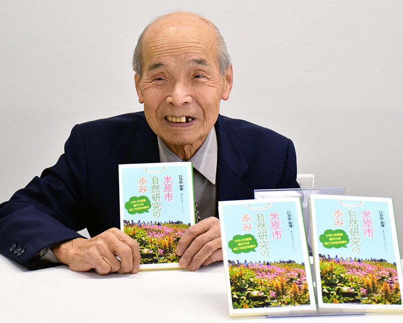 新刊「米原市自然研究の歩み」を手にする著者の口分田政博さん=滋賀県長浜市八幡東町で、若本和夫撮影