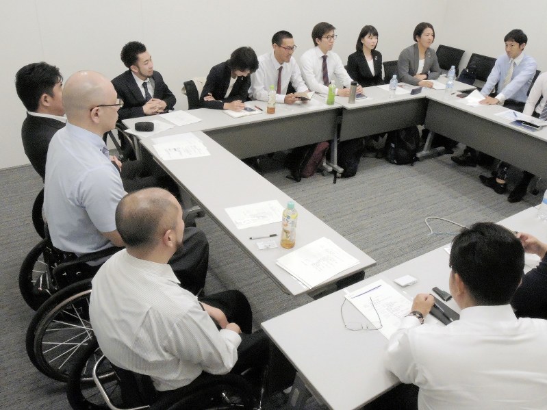 仲間の活動報告を聞くSMBC日興証券の障害者アスリートら=東京都中央区で、野島康祐撮影