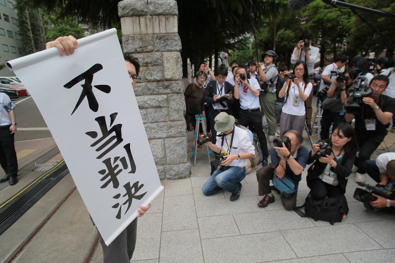 旧優生保護法について国に賠償を求めた訴訟の判決をうけ、「不当判決」と書かれた紙を掲げる弁護士=仙台市青葉区の仙台地裁で2019年5月28日午後3時、和田大典撮影