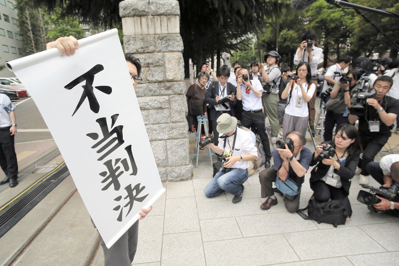 旧優生保護法について国に賠償を求めた訴訟の判決をうけ、「不当判決」と書かれた紙を掲げる弁護士=仙台市青葉区の仙台地裁で2019年5月28日午後3時、和田大典撮影