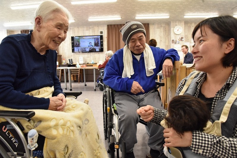 田端香さん(右)と長女の芽彩ちゃんの姿をみて笑顔をみせる入居者=神戸市で、筆者撮影