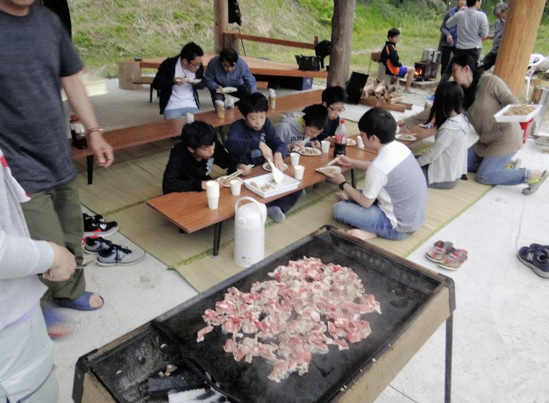 イノシシ肉の焼き肉を楽しむホームステイの中学生や住民=新潟県糸魚川市で