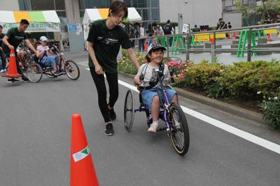 障害者用の自転車として開発されたハンドバイクを体験する参加者