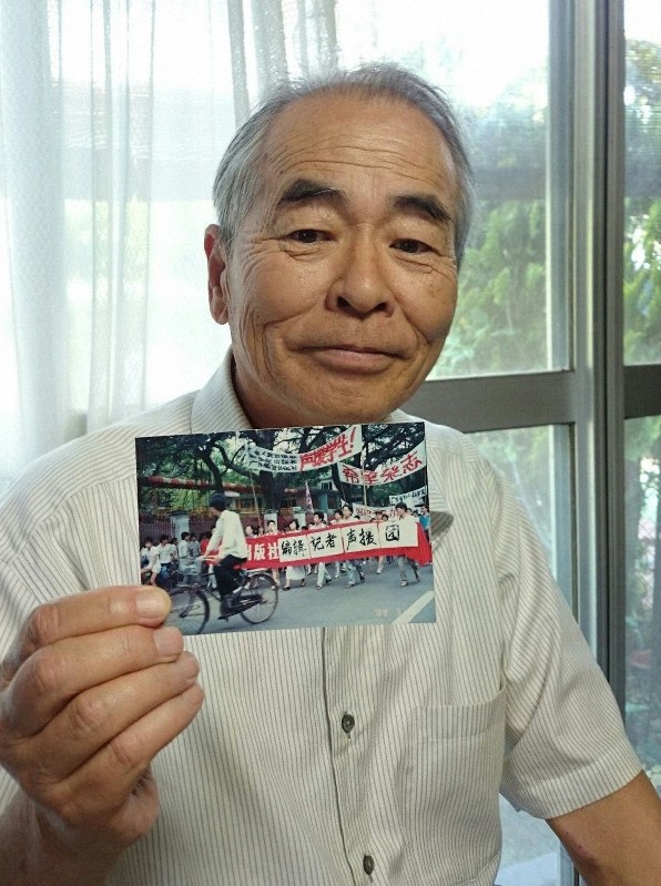 30年前に北京市内で民主化を求めるデモの様子を撮影した写真を見せる阿部昌一さん=群馬県沼田市で2019年6月3日、庄司哲也撮影