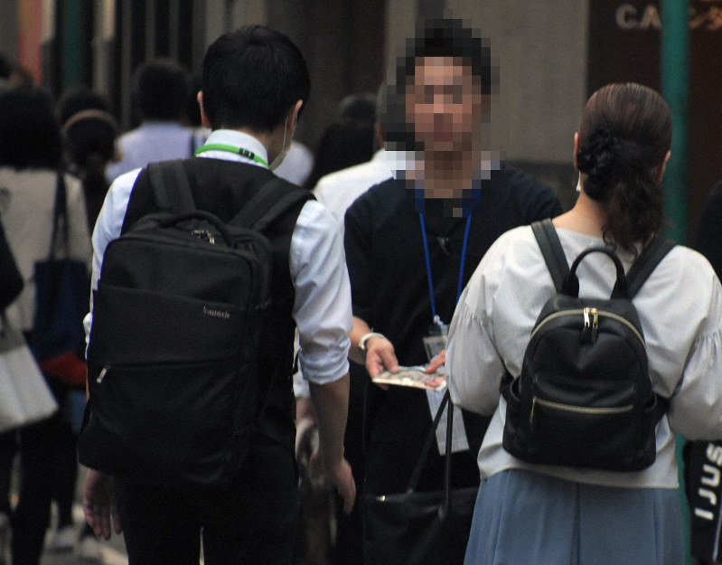 居酒屋のメニューを見せながら通行人に声をかける客引きの男性(右から2人目)=福岡市博多区博多駅中央街で2019年6月3日午後6時57分、一宮俊介撮影(画像の一部を加工しています)