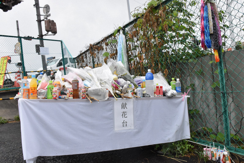 現場の交差点(奥)付近に設置された献花台。事故から1カ月が過ぎた9日に撤去されるという=大津市大萱6で2019年6月7日午後3時19分、菅健吾撮影