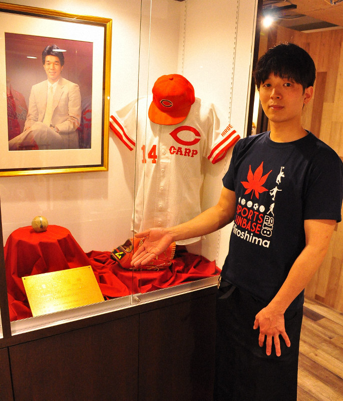 津田恒実さんの写真などの展示品を紹介する大毅さん=広島市南区で2019年6月7日、田中将隆撮影