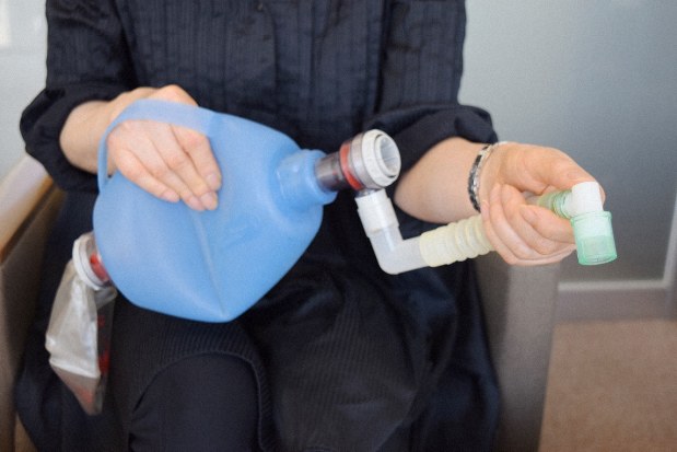 母親の介護で使った手動の人工呼吸器を手にする女性