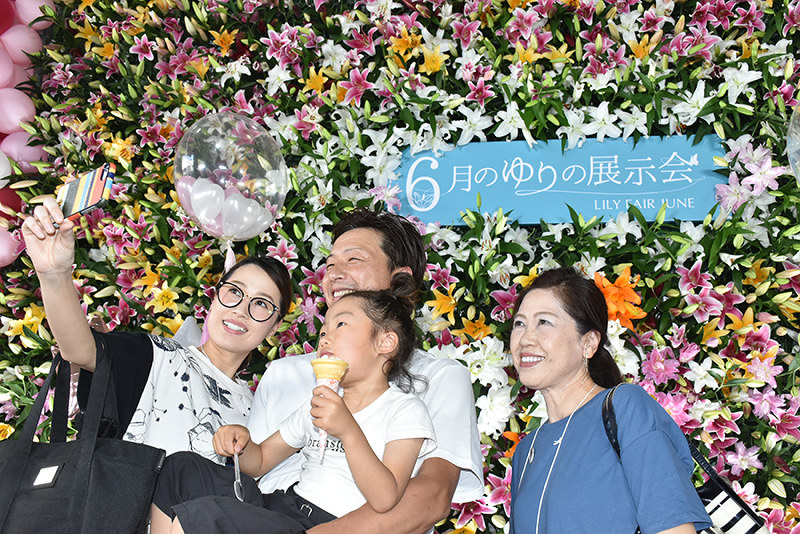「ゆりウォール」の前で記念撮影をする来演者=高知市長浜の中村農園で、北村栞撮影