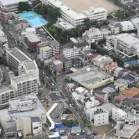警察官が刺され、拳銃が奪われた千里山交番（手前）。奥は、大阪府吹田市立千里第二小学校＝大阪府吹田市で２０１９年６月１６日午前８時４２分、本社ヘリから大西達也撮影