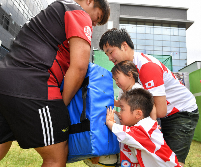 ラグビーのタックルを体験する親子ら＝愛知県豊田市で2019年6月16日、大西岳彦撮影