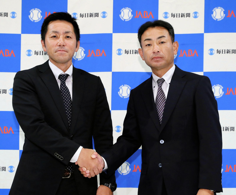 初戦での対戦が決まり、握手を交わすホンダ鈴鹿の丸井健太郎監督(左)と鷺宮製作所の目良宏監督=いずれも千代田区で、吉田航太撮影