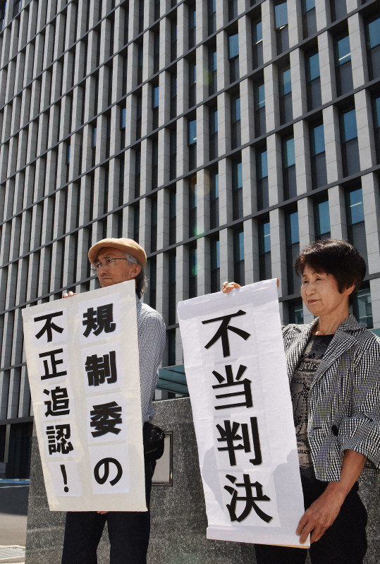 九州電力川内原発1、2号機の設置変更許可の取り消しが認められず、「不当判決」の旗を掲げる原告団=福岡市中央区の福岡地裁前で2019年6月17日午前11時4分、田鍋公也撮影
