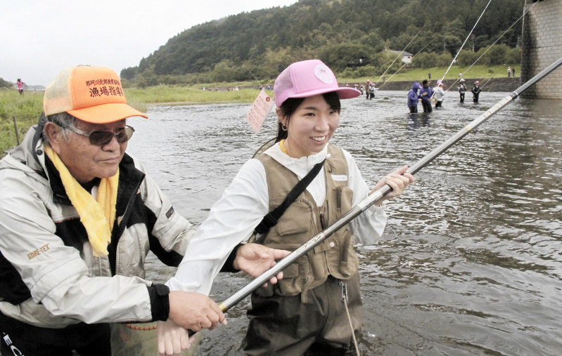 ベテラン釣り人のアドバイスを受けてアユ釣りに挑戦した宮下弥幸さん(右)=栃木県大田原市黒羽向町の那珂川で