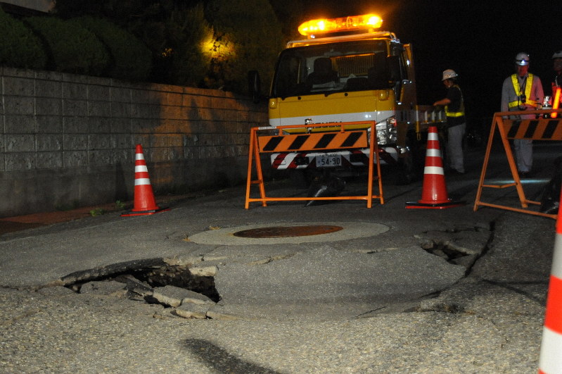 マンホールの周囲が陥没した道路=山形県鶴岡市城北町で2019年6月19日午前0時半過ぎごろ、長南里香撮影