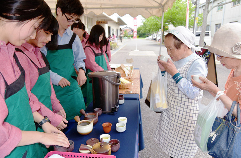自ら摘み取った政所茶を試飲してもらう生徒たち(左側)=滋賀県東近江市春日町の県立八日市南高校で、蓮見新也撮影