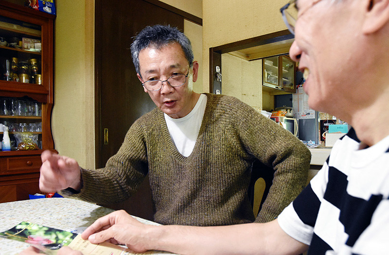 活動を支援している男性と打ち合わせをする古屋一之さん(左)=兵庫県三田市で、粟飯原浩撮影