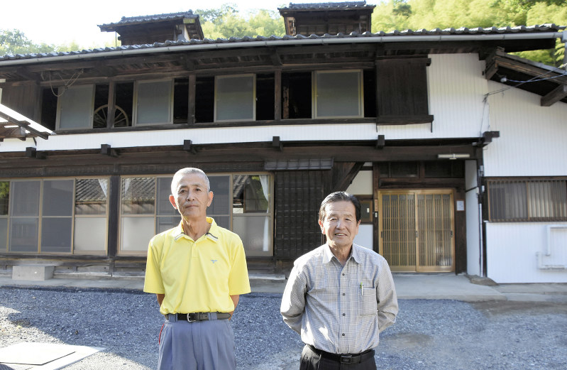 民泊施設「稲沢古民家 木村邸」の前に立つ山中修館長(左)と、NPO「本庄市げんきの郷本泉」の入利雄代表理事