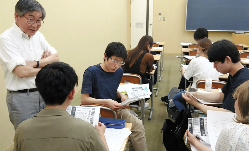 明治大で、学生に新聞の使い方を説明する藤井剛特任教授(左)=明治大で