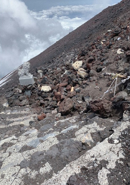 崩れた石積みに覆われた山頂付近の登山道=山梨県提供