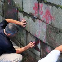 赤坂御用地の石垣に赤い塗料で書かれた落書きを落とす人たち＝東京都港区で2019年6月25日午前11時19分、玉城達郎撮影