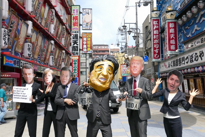 G20各国首脳のマスクをかぶり、地球温暖化対策強化を求めるパフォーマンスをするNGOメンバー=大阪市内で2019年6月28日(No Coal Japan提供)