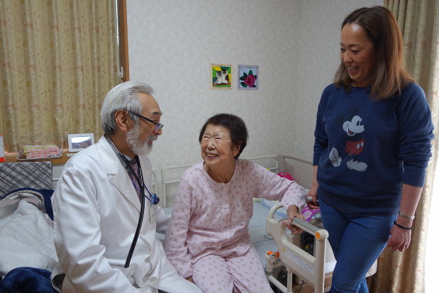訪問診療で80代女性に「調子はどうですか?」と語りかける高林克日己さん=千葉県松戸市で2019年3月25日、中村好見撮影