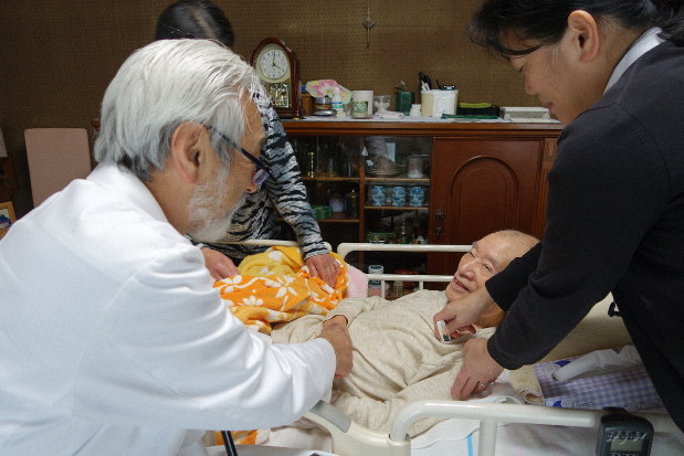 訪問診療した90代男性の手を握る高林さん